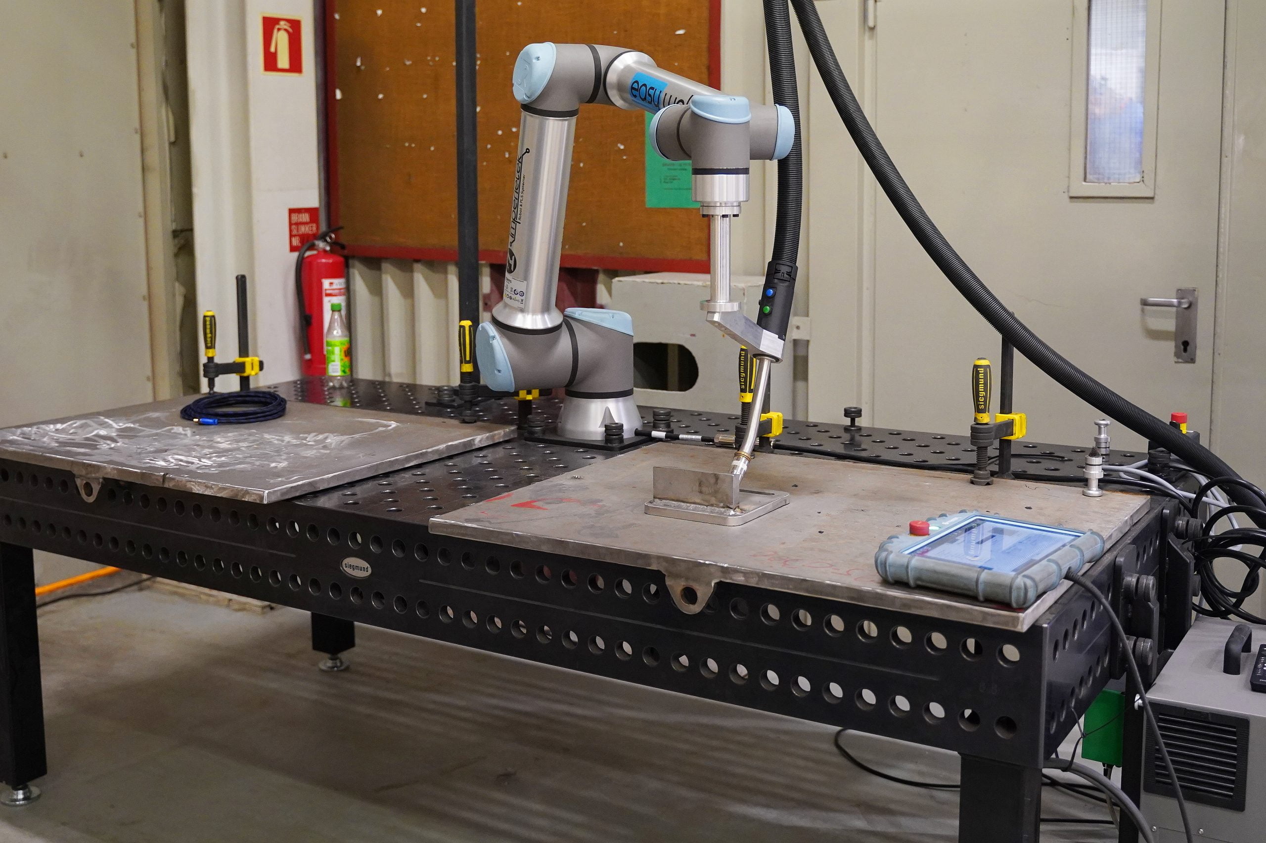samarbeidende robot som er montert på et bord med styreflate i høyre hjøre av bildet.