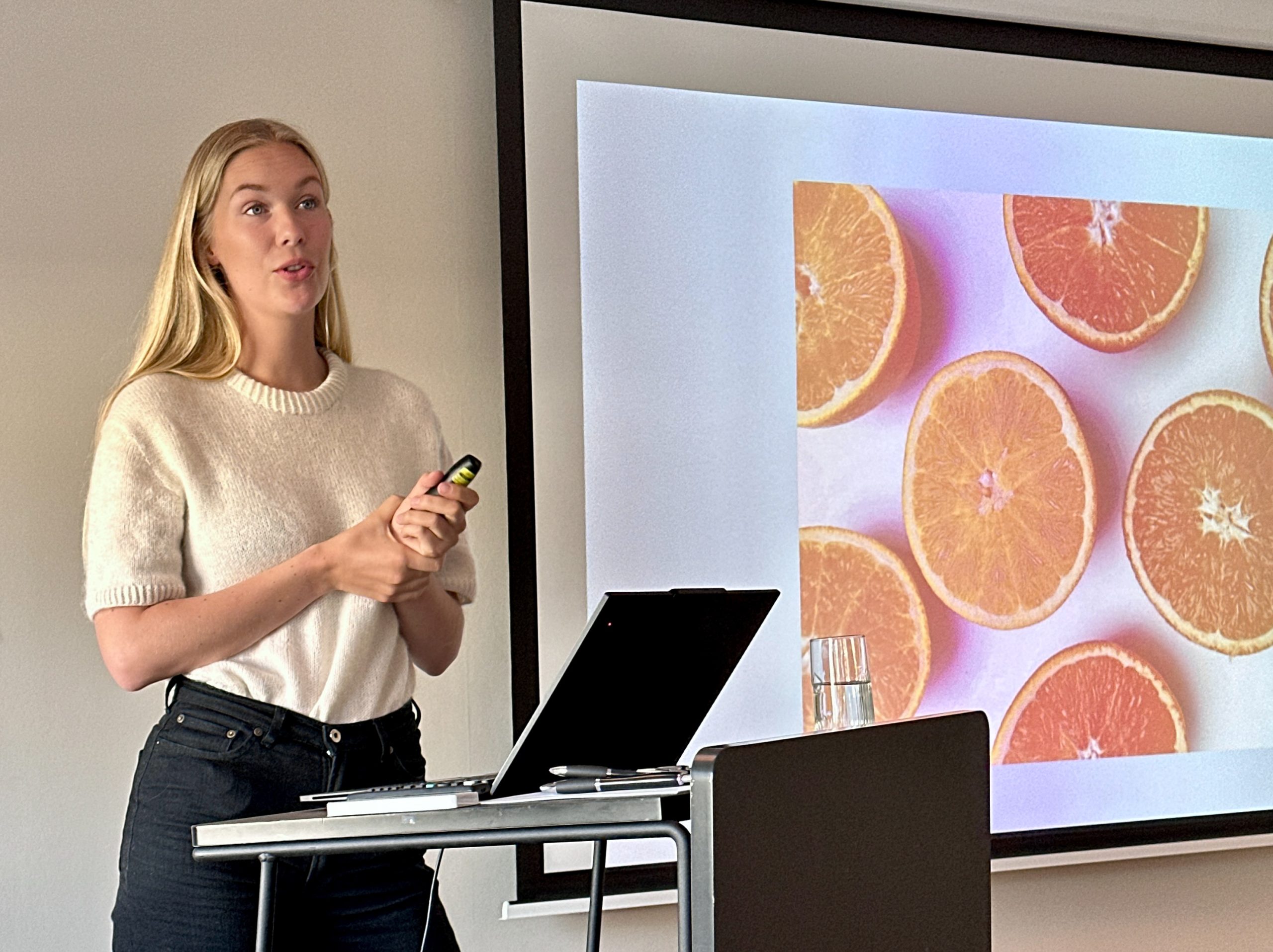 Karen Elene Thorsen foran sin presentasjon med bilde av appelsiner.