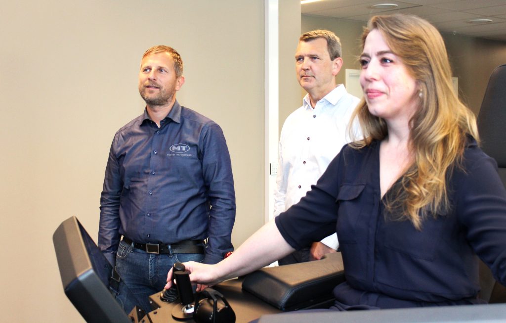 Sveinung Tollefsen, Jon S. Hjørungenes og Monica Aase viser hvordan demoutstyret deres virker. Monica sitter i demostolen og styrer fartøyet.